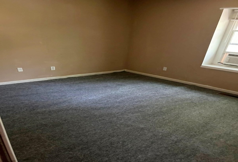 Spare room with dark colored carpet and baseboards