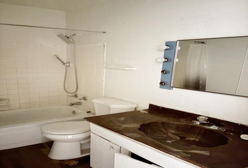 Full bath with vanity, shower / tub combo with curtain, and dark wood-style flooring
