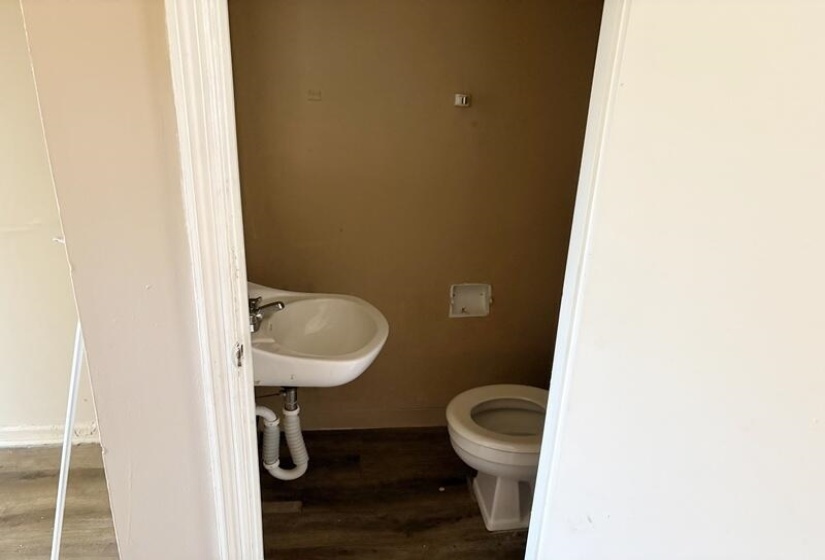 Bathroom with toilet and dark wood-style flooring