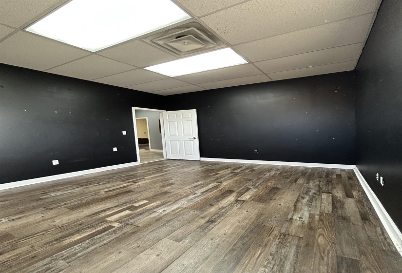 Spare room with wood finished floors and a drop ceiling