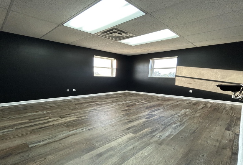 Unfurnished room featuring a drop ceiling and dark wood-style floors