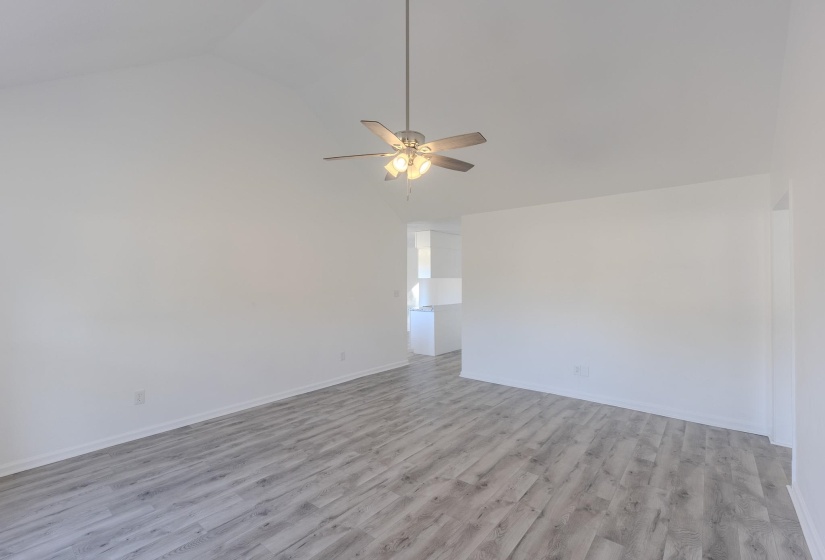 Unfurnished room featuring light wood-type flooring, vaulted ceiling, and a ceiling fan