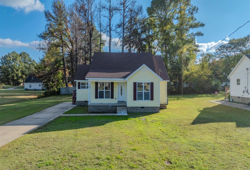 View of front of property with crawl space, a front lawn, a shingled roof, and covered porch