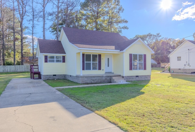 View of front facade featuring crawl space, roof with shingles, a front lawn, covered porch, and concrete driveway