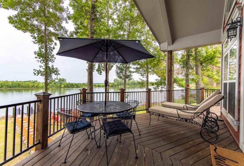 Wooden deck with a water view and outdoor dining space