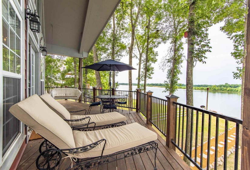 Wooden terrace featuring a water view and outdoor dining space