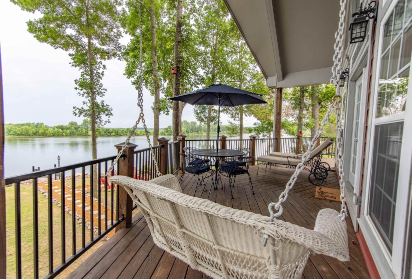Wooden deck with outdoor dining space and a water view