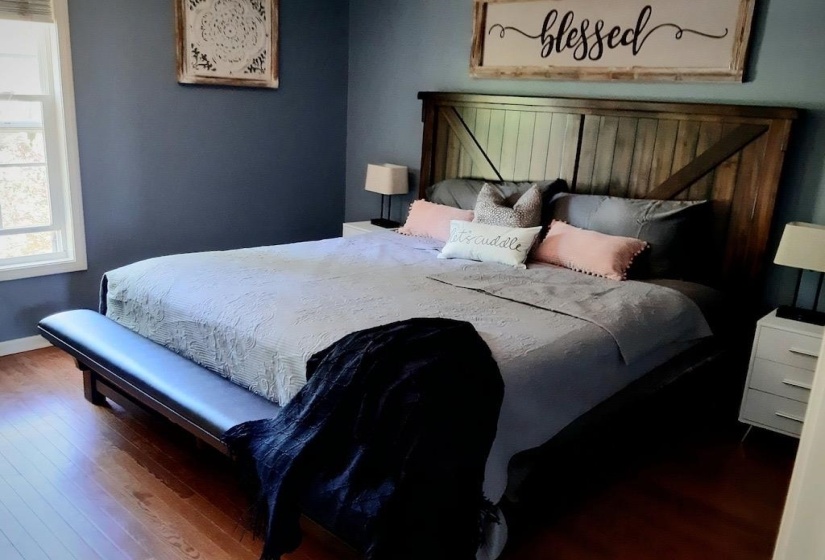 Bedroom with dark wood-style flooring and baseboards