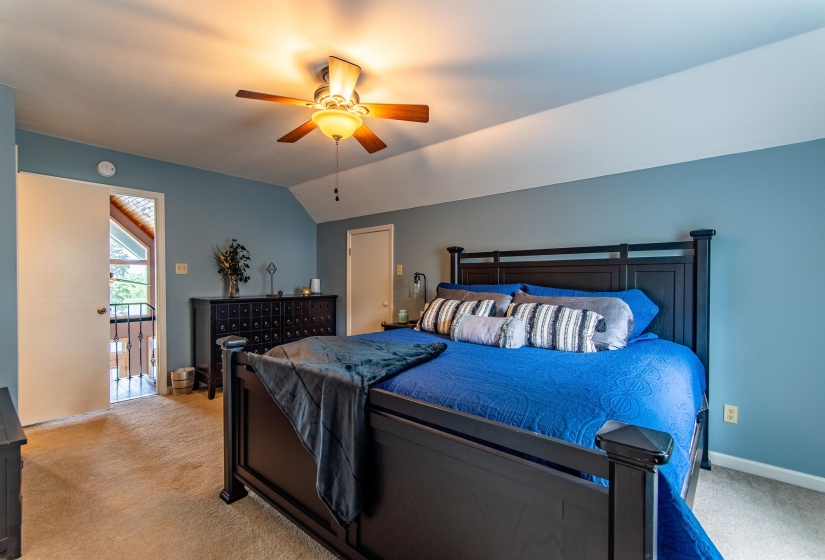 Bedroom featuring light carpet, lofted ceiling, and ceiling fan