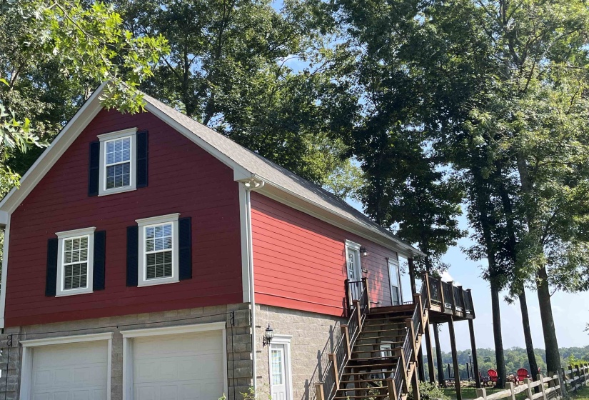 View of side of home with a garage and stairs