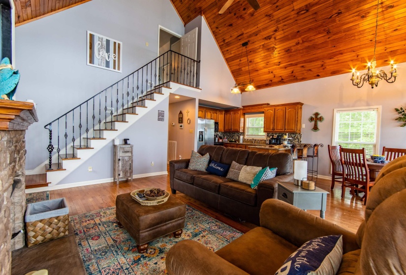 Living area featuring wood finished floors, high vaulted ceiling, stairway, wood ceiling, and a chandelier