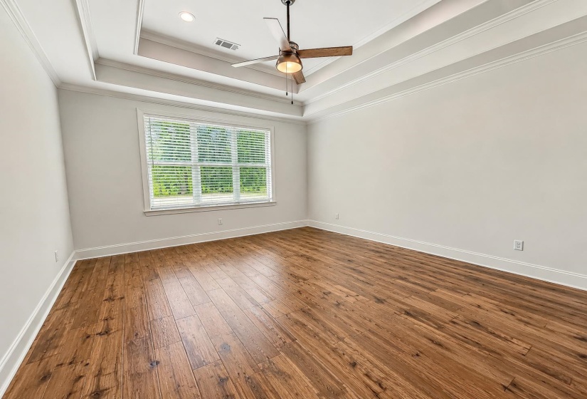 with double trayed ceilings, hardwood flooring and is on a split bedroom plan downstairs