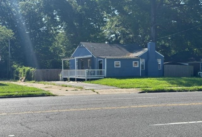 View of front facade with a porch and a chimney