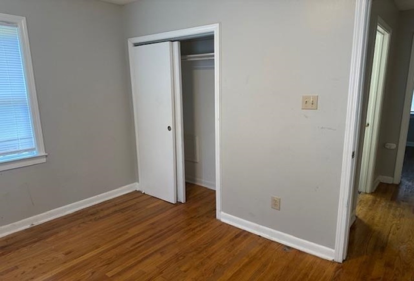 Unfurnished bedroom featuring a closet and wood finished floors