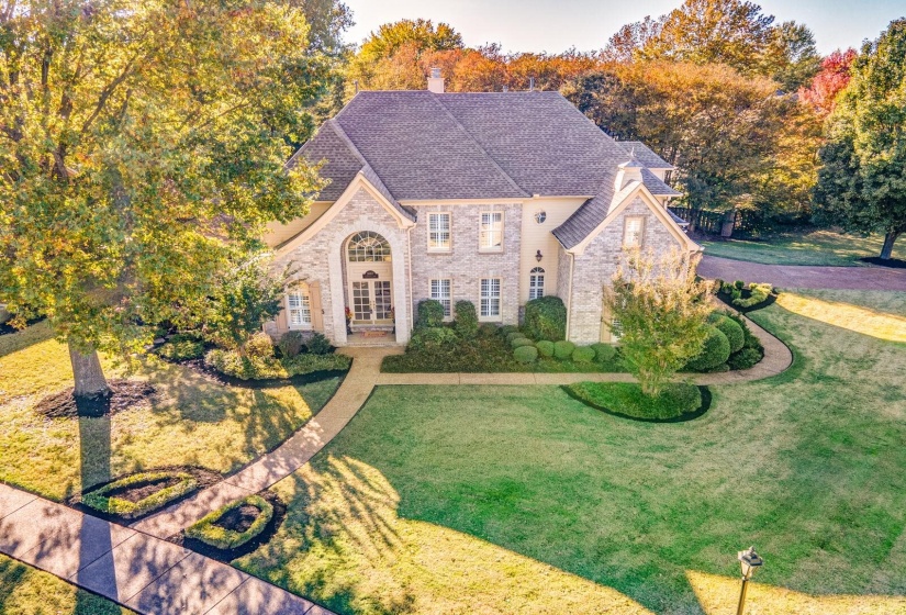 French country home with a front lawn, roof with shingles, a chimney, and brick siding