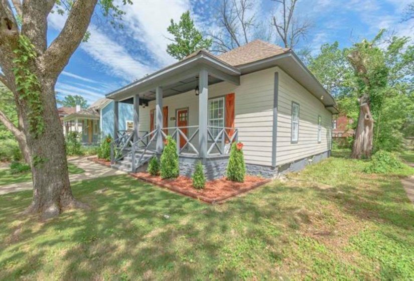 View of front facade featuring covered porch, a front lawn, and crawl space