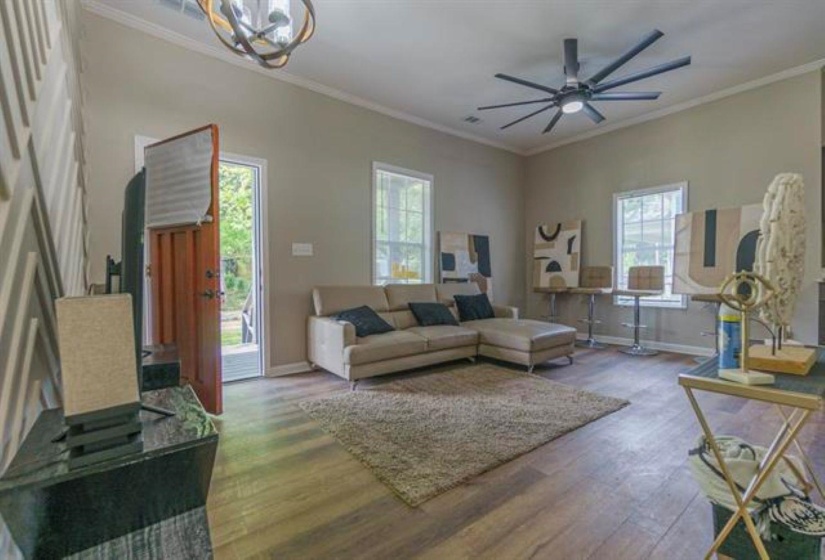 Living room featuring ornamental molding, wood finished floors, and ceiling fan