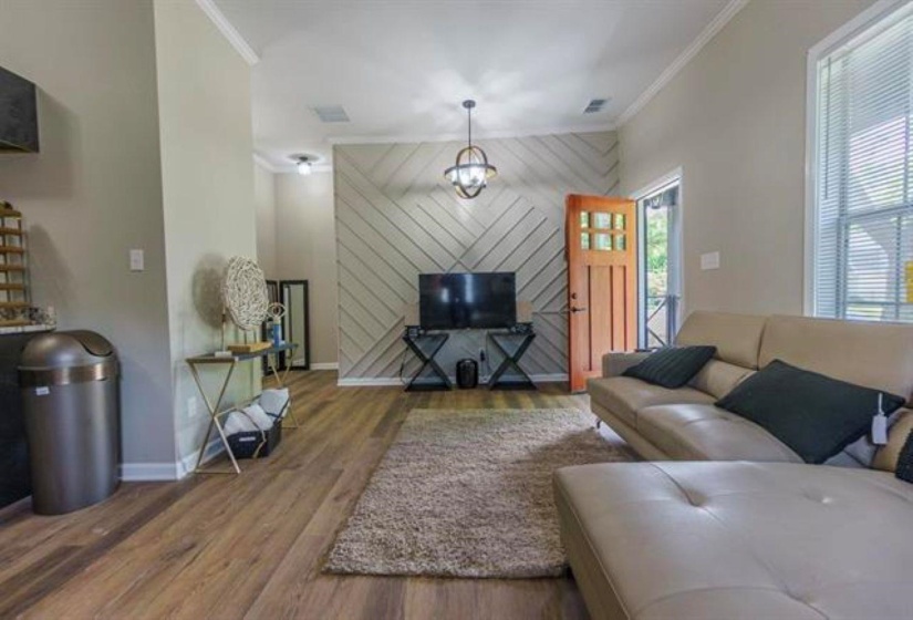 Living area featuring ornamental molding and wood finished floors