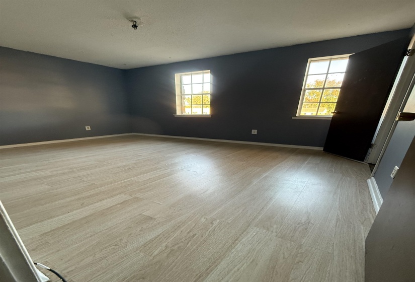 Spare room with light wood-style flooring, healthy amount of natural light, and a textured ceiling