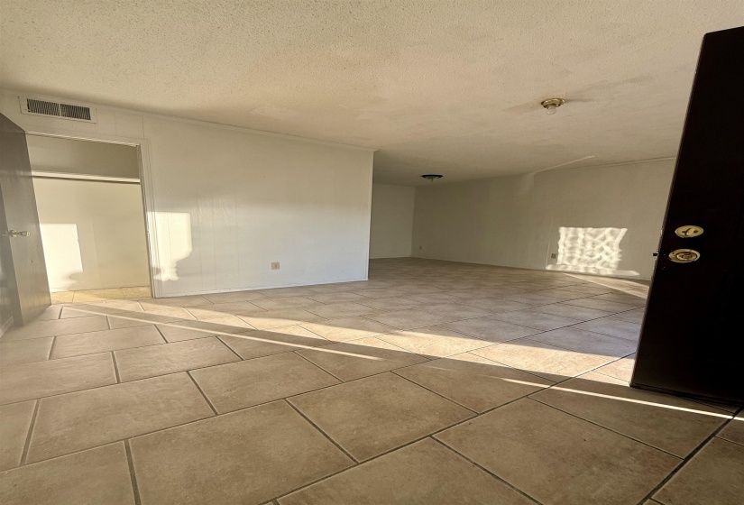 Empty room with a textured ceiling and light tile patterned floors