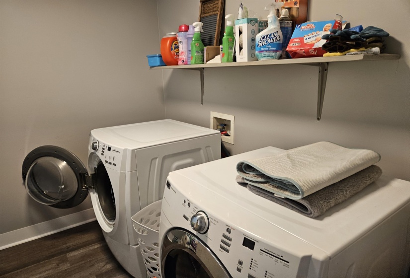 Washroom featuring dark wood-type flooring and washer and clothes dryer
