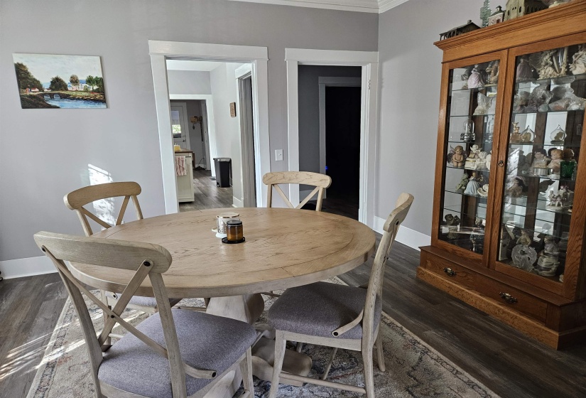 Dining area with dark wood finished floors and ornamental molding