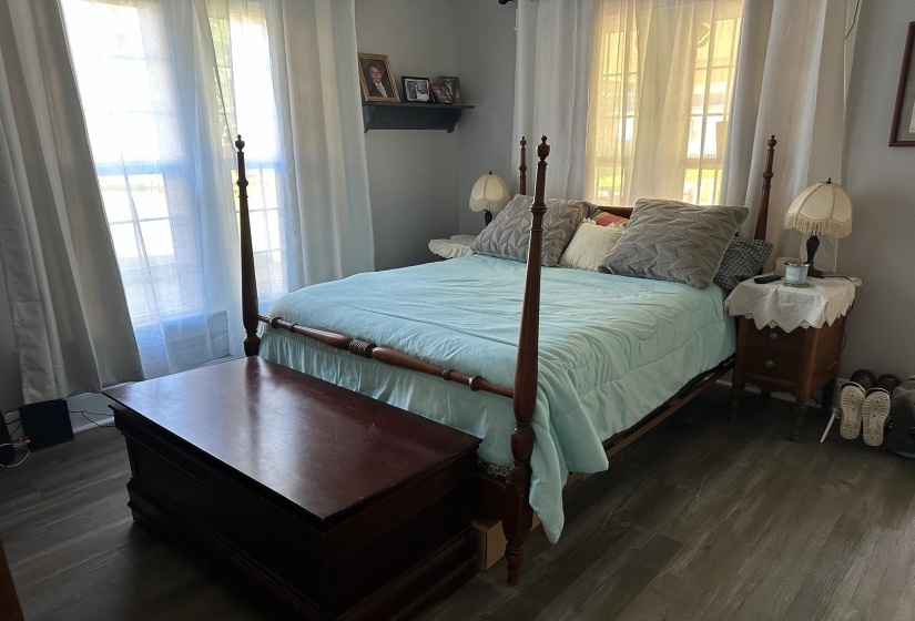 Bedroom with multiple windows and dark wood-type flooring