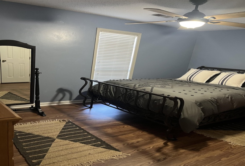 Bedroom featuring ceiling fan, dark wood finished floors, and a textured ceiling