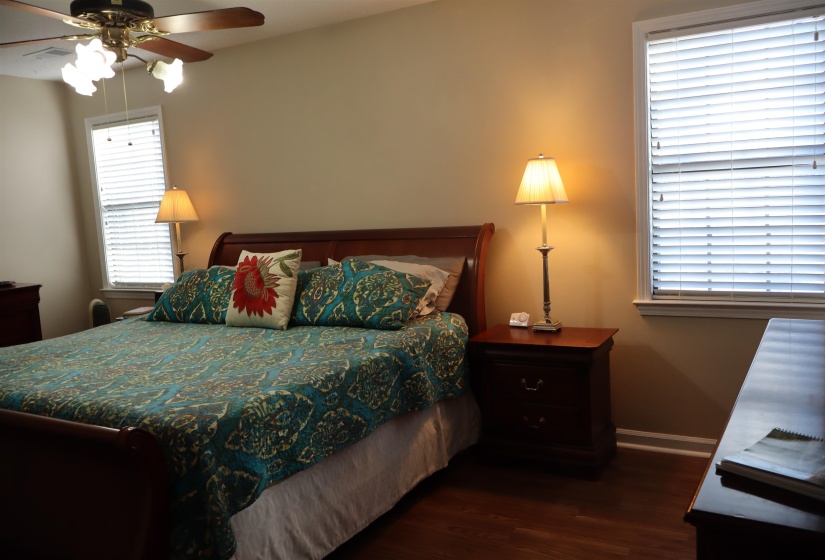 Bedroom with dark wood-style flooring and a ceiling fan