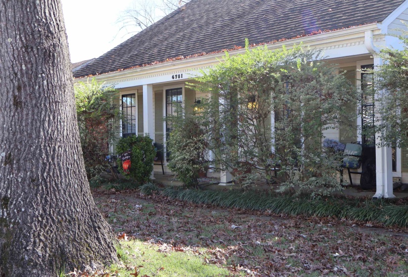 View of side of property with covered porch and a shingled roof