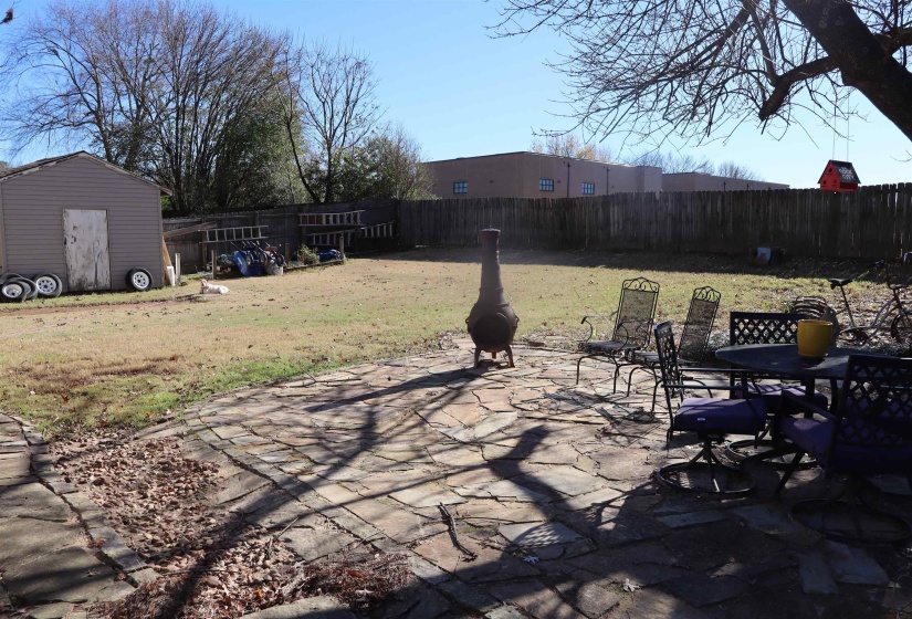 Fenced backyard with a storage shed, a patio, and outdoor dining space