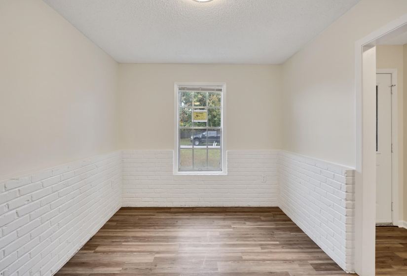 Spare room featuring wood finished floors, wainscoting, and a textured ceiling