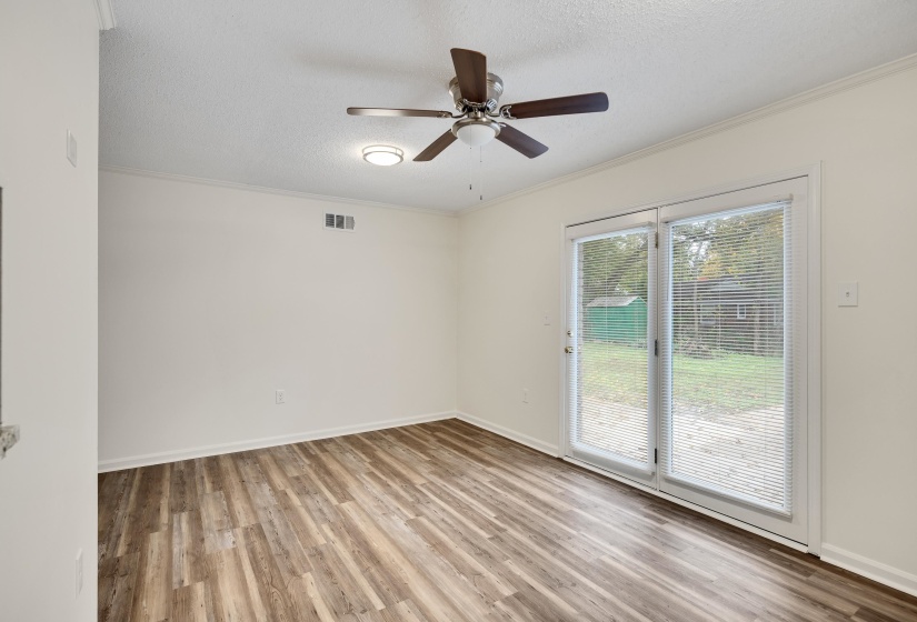 Spare room with a textured ceiling, ornamental molding, light wood-style floors, and a ceiling fan