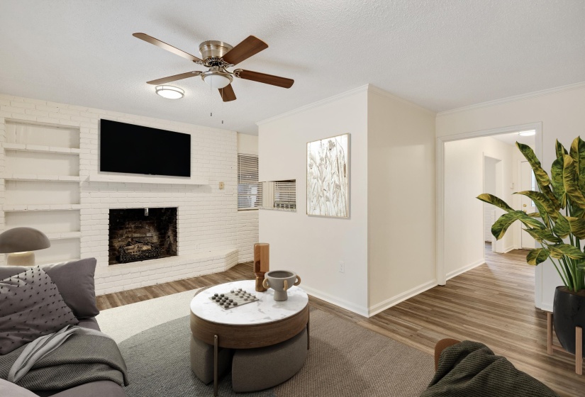 Living area with wood finished floors, a textured ceiling, a fireplace, ceiling fan, and ornamental molding
