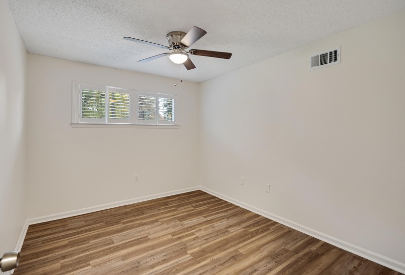 Unfurnished room featuring wood finished floors, a textured ceiling, and a ceiling fan