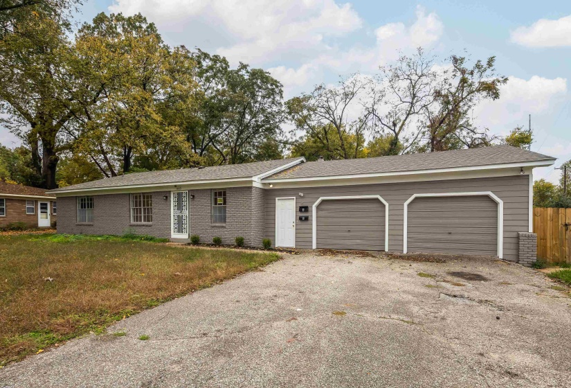 Ranch-style house featuring driveway, brick siding, a front lawn, and an attached garage
