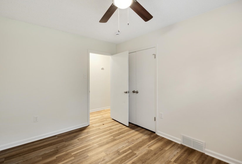 Unfurnished bedroom featuring wood finished floors, ceiling fan, and a closet