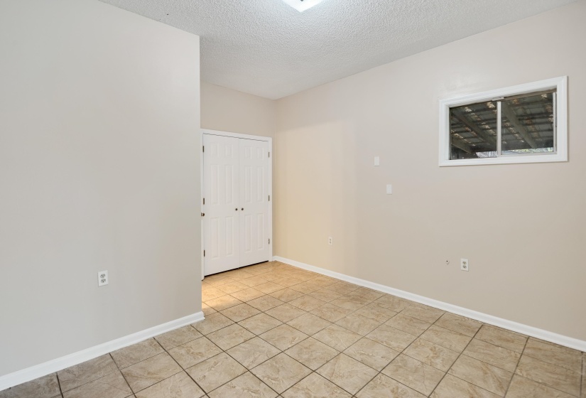 Empty room featuring a textured ceiling and light tile patterned flooring