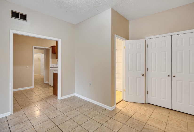 Unfurnished bedroom with a textured ceiling, light tile patterned floors, and a closet