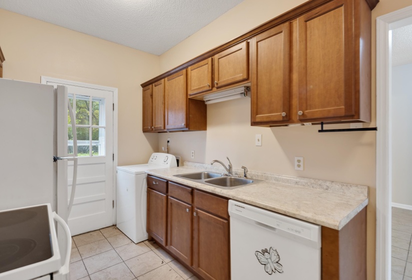 Laundry area with light tile patterned floors, a textured ceiling, and washing machine and dryer