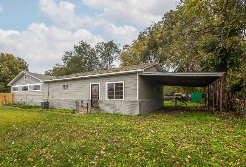Rear view of property with an attached carport and brick siding