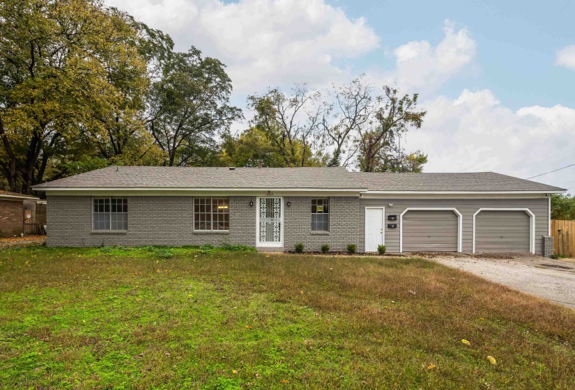 Ranch-style house with driveway, brick siding, and an attached garage
