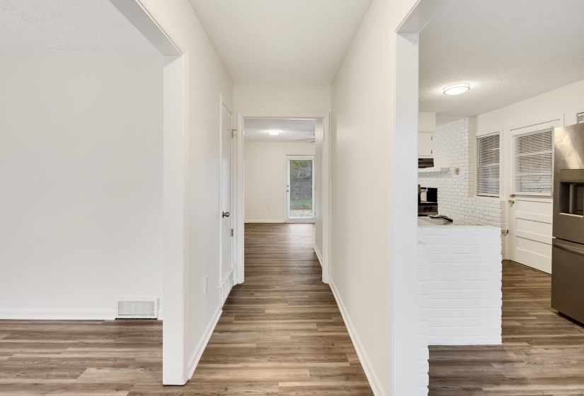 Hallway featuring light wood-style flooring and a textured ceiling