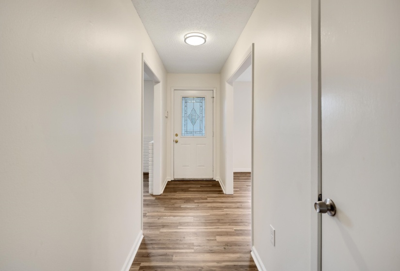Doorway to outside with wood finished floors and a textured ceiling
