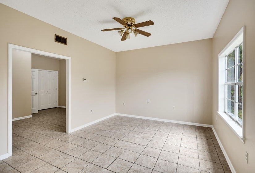 Unfurnished room with ceiling fan, a textured ceiling, and light tile patterned flooring