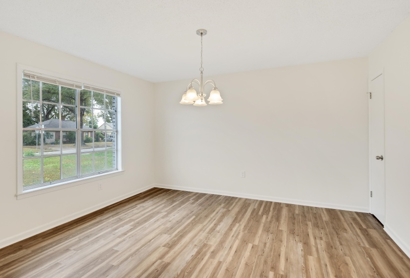 Unfurnished room featuring light wood-type flooring and a chandelier