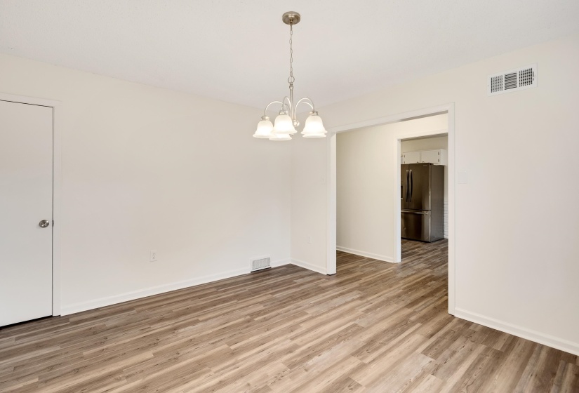 Unfurnished room featuring light wood-type flooring and a chandelier