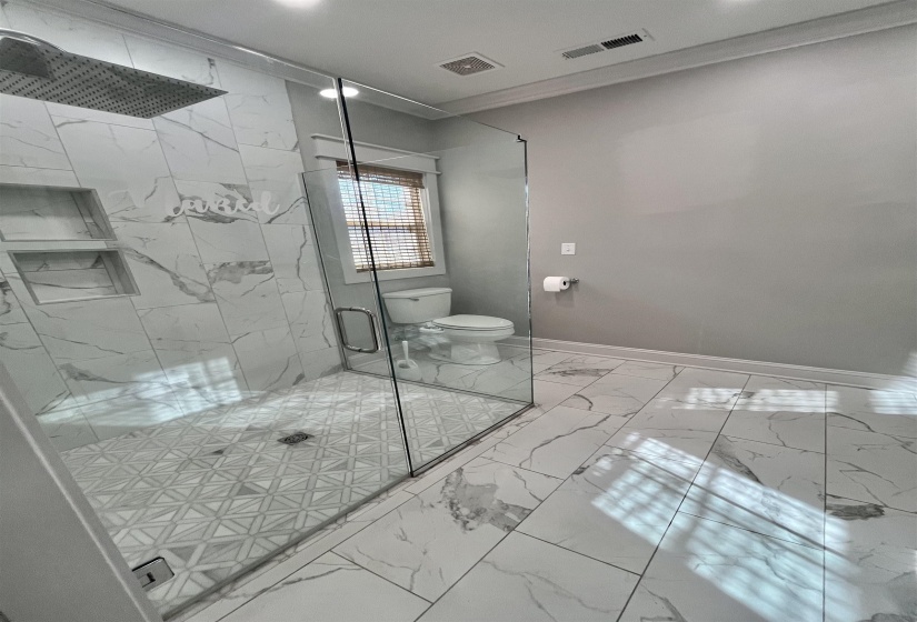Full bath with light marble finish floors, a marble finish shower, ornamental molding, and recessed lighting