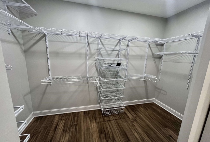 Spacious closet with dark wood-style floors