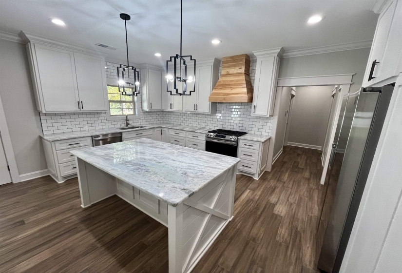 Kitchen featuring light stone counters, dark wood-style flooring, white cabinets, ornamental molding, and recessed lighting